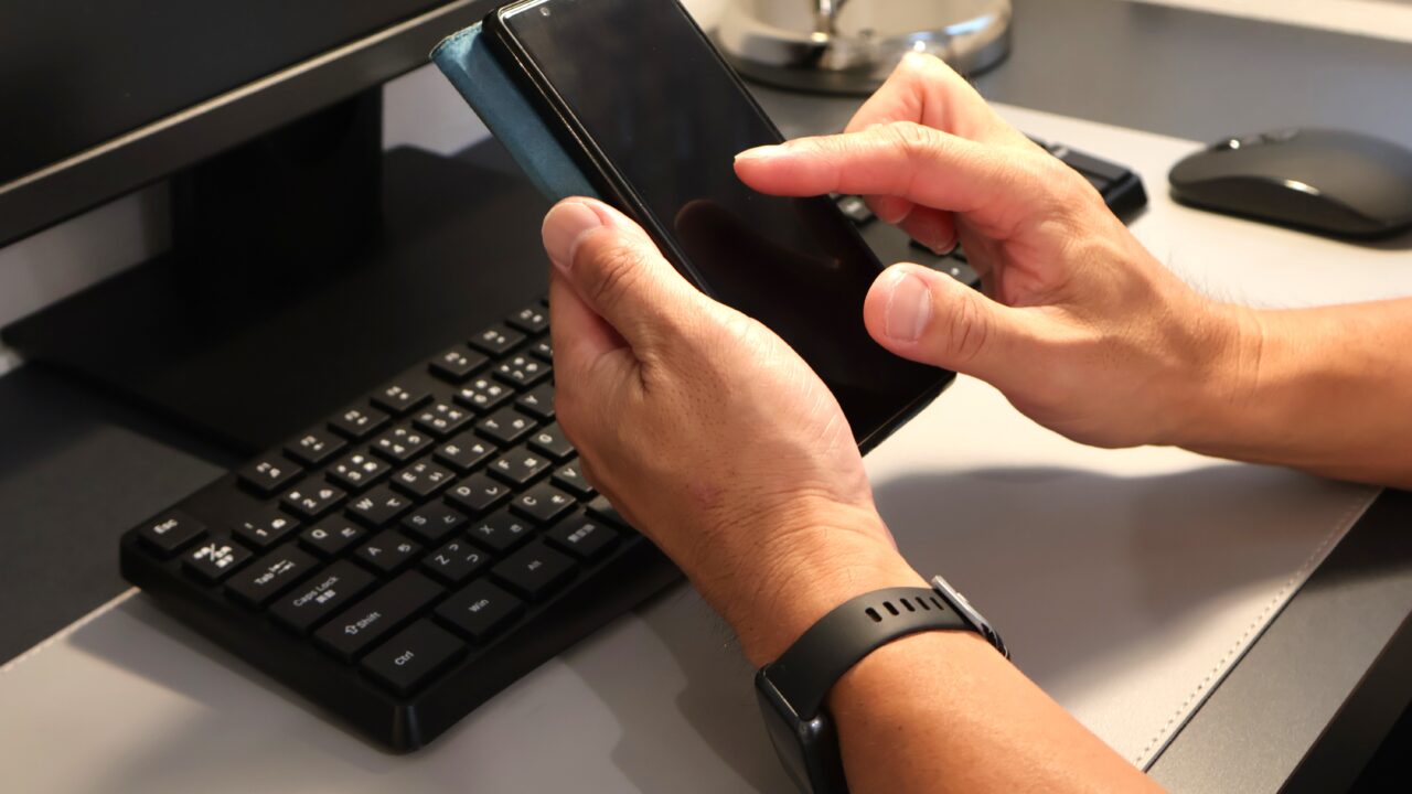 ハローワークインターネットサービスにログインするため、スマホで求職番号を入力する男性。エラー解決のために画面を操作している様子。